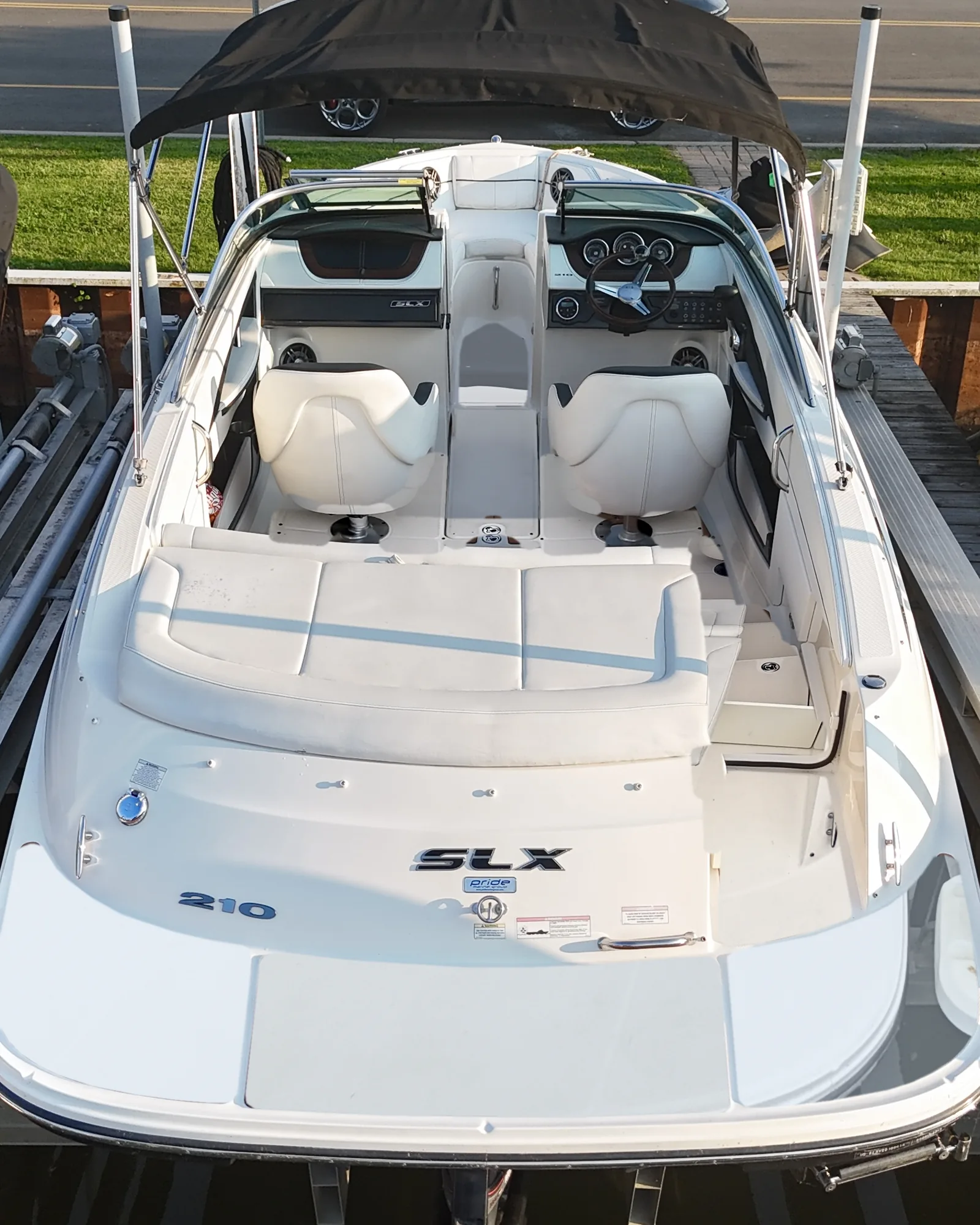 A 2014 Sea Ray 210 SLX on its lift, seen from above, with a bare white deck