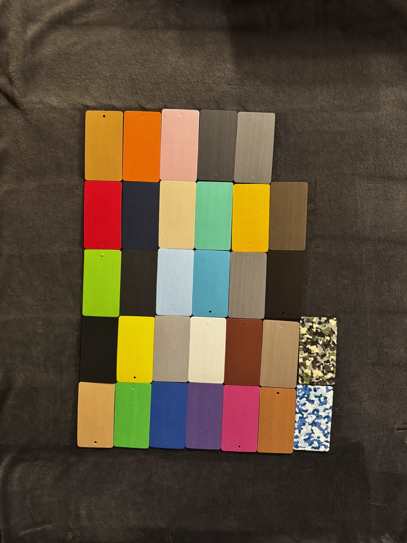 Foam sample chips in thirty-one colours laid out on dark cloth